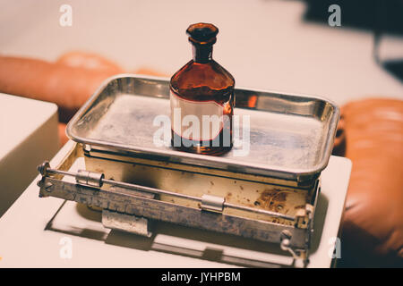 Alte, leere Medizin Flasche auf der Skala - Vintage Look Stockfoto