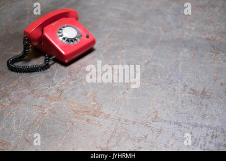 Leere vintage Tisch mit roten Telefon im Hintergrund - Telefon auf dem Schreibtisch Stockfoto