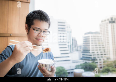 Asiatischer mann Essen Mittagessen mit Hand chopstick Stockfoto