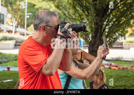 BUDAPEST, Ungarn - 11. AUGUST 2017: Zwei Menschen Bilder in Budapest Park, eine mit einem semi-professionelle DSLR-Kamera, der andere mit einem Amat Stockfoto