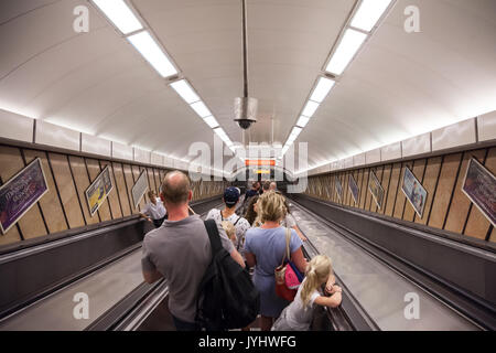 BUDAPEST, Ungarn - 12 August, 2017: die Menschen gehen, eine U-Bahnstation von Budapest auf einer Rolltreppe Bild einer Familie eine Rolltreppe nach unten in eine Stockfoto