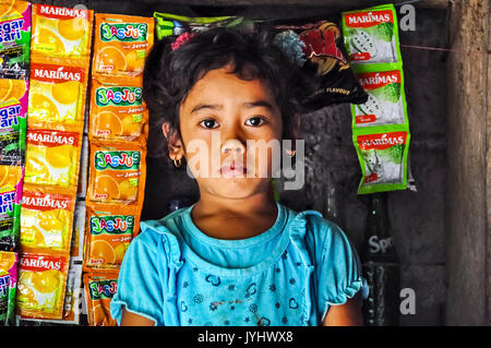 Asien, Südostasien, Indonesien, Bali, Sidemen. Porträt eines kleinen Mädchens im Süßwarenladen. Stockfoto