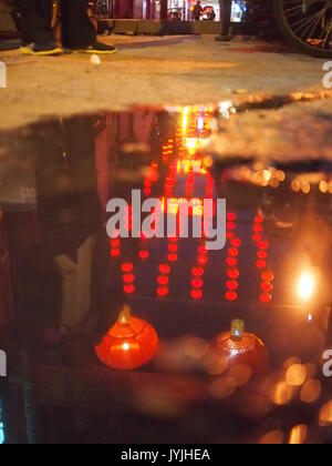 Eine Pfütze in Peking Hutong spiegelt die Rote Laternen Stockfoto