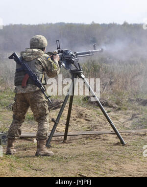 Der Soldat mit dem ukrainischen Land Kräfte feuert eine Degtyaryov Shpagin große Kaliber Heavy Machine Gun Stockfoto