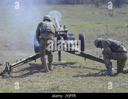 Der Soldat mit dem ukrainischen Land Kräfte Brände ein 82 mm Mörser Stockfoto
