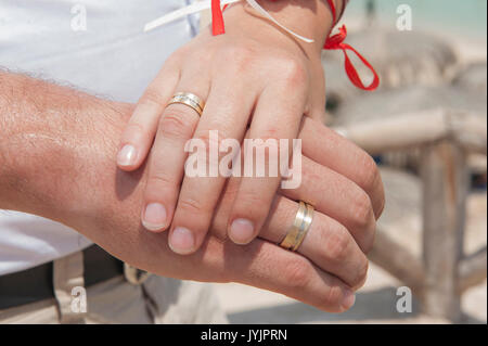 Neu verheiratete Paare halten sich an den Händen und zeigt ihre Hochzeit Ringe Stockfoto