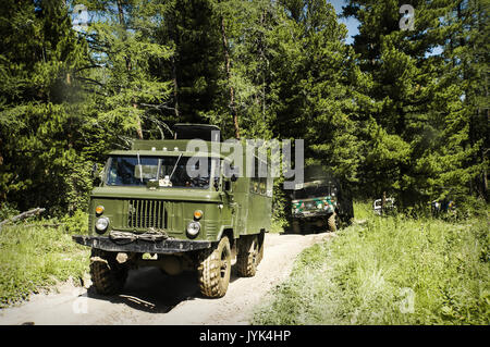 Militärisches Fahrzeug in den Wald, alte russische militärische Fahrzeuge fahren auf eine schlechte Piste durch die Taiga Stockfoto
