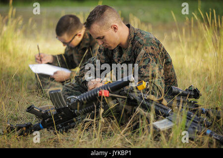 Us Marine Corps Hauptgefreiter Mathew Dekan, ein M27 automatische rifleman Infanterie im 1. Squad, mit 1St Bataillon, 25 Marine Regiment, 4 Marine Division, Marine Reserve, schließt einen von 3 schriftlichen Prüfungen während des Super Squad Wettbewerb auf gemeinsamer Basis Elmendorf-Richardson, Alaska, Aug 5, 2017. Super Squad Wettbewerbe wurden entwickelt, um eine 14-Mann Infanterie Squad in ein weites Feld und Live-fire Evolution zu bewerten. (U.S. Marine Corps Foto von Sgt. Justin A. Bopp/Freigegeben) Stockfoto