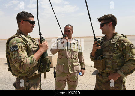 Us Air Force Senior Airman Troy Ondrey (links) und Staff Sgt. Matthäus Ramos (rechts), beide Fluglotsen eingesetzt zur Unterstützung der Combined Joint Task Force - inhärenten lösen und an die 370 Air Expeditionary Advisory Group, Abteilung 1, Arbeiten mit einem irakischen Luftstreitkräfte Air Traffic Controller die Ankunft eines ankommenden Flugzeuge zu Qayyarah West Airfield, Irak, 1. Juli 2017 zu koordinieren. Lückenlose Kontrolle der irakischen und Koalition Luftverkehrs gewährleisten, 370. der US-Air Force AEAG unterstützt die CJTF-OIR beraten und Mission unterstützen, indem Sie ein kleines Team von Luft adviso Stockfoto