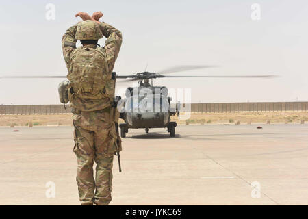 Us Air Force Tech. Sgt. Joseph Tenebruso, der expeditionary Wartung Flug chief eingesetzt zur Unterstützung der Combined Joint Task Force - inhärenten lösen und an die 370 Air Expeditionary Advisory Group, Loslösung 1 zugewiesen, der Streckenposten in einem UH-60 Black Hawk Hubschrauber Qayyarah West Airfield, Irak, 2. Juli 2017. Die expeditionary Wartung liaisons Marschall ankommende Flugzeuge zu Qayyarah West ein effizientes parken Plan an die logistische Drehscheibe für die mosul Offensive zu erhalten. CJTF-OIR ist die globale Koalition zu besiegen ISIS im Irak und in Syrien. (U.S. Air Force Foto von Tech. Sgt Stockfoto