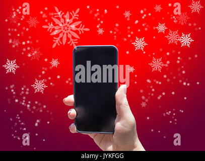 Das Telefon in der Hand auf dem roten Hintergrund Stockfoto