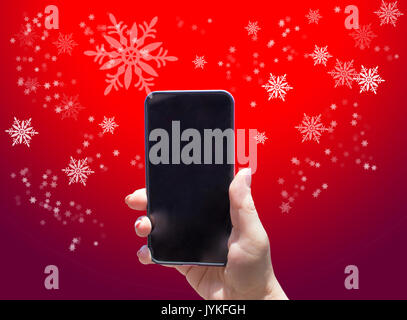 Das Telefon in der Hand auf dem roten Hintergrund Stockfoto