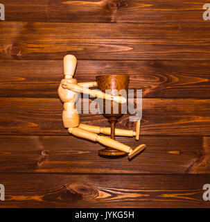 Holz- Mann mit Glas Wein Stockfoto