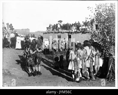 Eine Linie der tanzenden Braves in der Hopi Snake Dance Zeremonie mit Zuschauern, Oraibi, California, Ca. 1898 (CHS 3709) Stockfoto