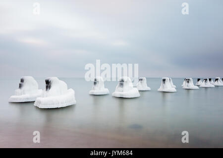 Die Eiskappen auf alten Holzpfählen im Einklang und Ruinen von Torpedo Gebäude Stockfoto