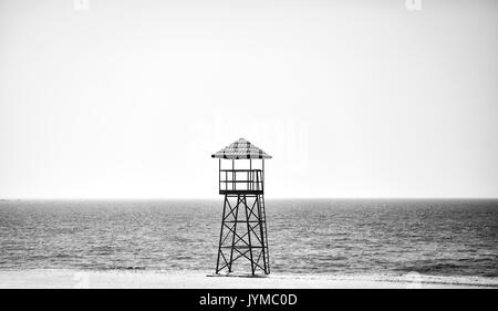 Schwarz-weiß Bild von einem Bademeister Turm auf einem leeren Strand. Stockfoto