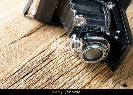 Alte falten Kamera auf eine strukturierte Holzmöbeln im Landhausstil Oberfläche Stockfoto