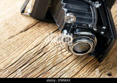 Alte falten Kamera auf eine strukturierte Holzmöbeln im Landhausstil Oberfläche Stockfoto