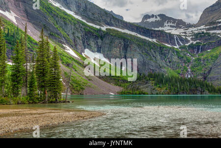 Ein Wasserfall fließt vom Grinnell Glacier in türkisblaue See in Grinnell Glacier National Park, Montana Stockfoto