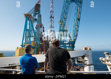 Zwei Männer beobachten Hubarbeiten an Bord der Saipem S7000 schweres Schiff. Credit: LEE RAMSDEN/ALAMY Stockfoto