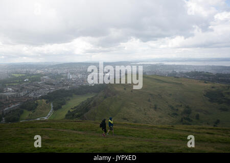 Wanderer auf dem Weg zur Spitze in eine Regendusche. Der Gipfel des König Arthur's Seat ist ein beliebtes Ausflugsziel sowohl für Einheimische als auch für Touristen. Der Höhepunkt und s Stockfoto