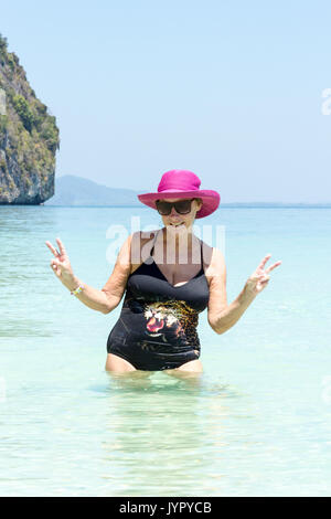 Ältere Frau mit rosa Hut im Meer, Koh Lao Liang, Trang, Thailand Stockfoto