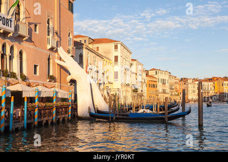 Sonnenuntergang auf dem Canal Grande, Venedig, Italien mit Lorenzo Quinn unterstützen mit den Händen unterstützen Ca'Sagredo Hotel und Gondeln. Das italienische a Stockfoto