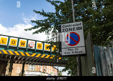 Kontrollierte Zone Schild mit Eisenbahnbrücke im Hintergrund. Stockfoto