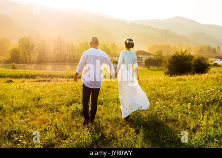 Paar auf dem Feld mit den romantischen Sonnenuntergang Stockfoto