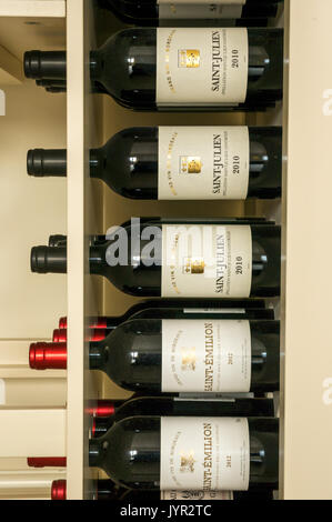 Rotwein Flaschen in einem Rack aus der Region Bordeaux in Frankreich, einschließlich Saint Julien und Saint Emilion. Stockfoto