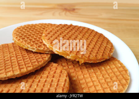 Platte von Stroopwafel Cookies, leckeren, holländischen traditionellen Süßigkeiten auf hölzernen Tisch serviert Stockfoto