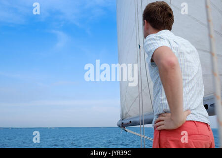 Junge kaukasier Sailor gerne entspannen auf Segelboot Yacht. Er loooks beiseite und Traum. Stockfoto