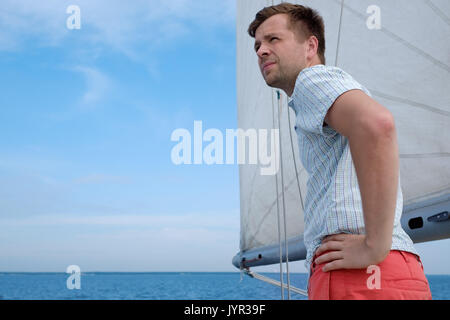 Junge kaukasier Sailor gerne entspannen auf Segelboot Yacht. Er loooks beiseite und Traum. Stockfoto