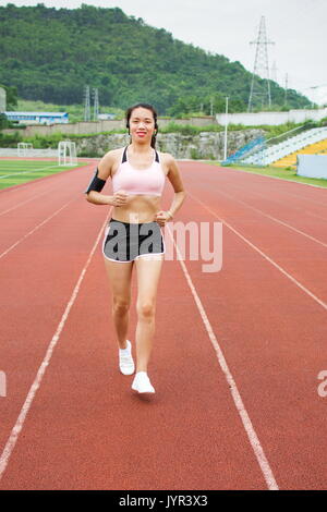 Mädchen joggen mit Smartphone auf eine Laufstrecke Stockfoto