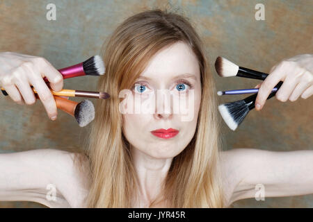 Junge Frau mit Make up Pinsel nahe an ihr Gesicht Stockfoto
