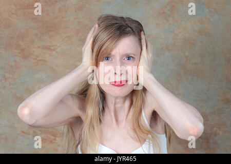 Young woman holding her ears to protect them from loud noise Stockfoto
