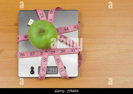 Green Apple auf digitale Küchenwaage in Maßband mit fit Anmelden Anzeige umgebrochen Stockfoto