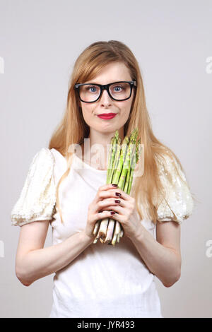 Junge Frau mit einem Bündel Spargel in Ihren Händen Stockfoto