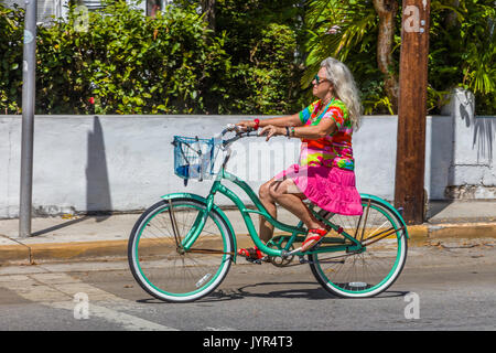 Bunt gekleidete Frau Reiten Fahrrad in Key West Florida Stockfoto