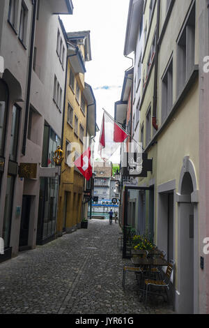 Downtown City Szene von schmalen Einkaufsstraße mit vielen Schweizer Fahnen aus Zürich Schweiz Stockfoto