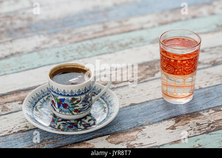 In der Traditionellen türkischen Kaffee Tasse mit Glas Wasser auf vintage Tabelle Stockfoto
