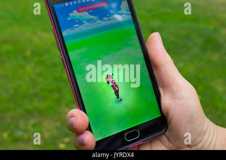 Dnipropetrowsk, Ukraine - 23. Juli 2016: Die weibliche Hand, die eine Telefon mit Spiel Pokemon gehen im Park Stockfoto