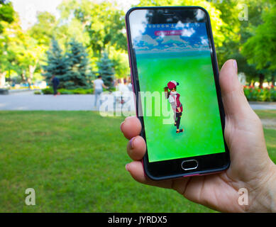 Dnipropetrowsk, Ukraine - 23. Juli 2016: Die weibliche Hand, die eine Telefon mit Spiel Pokemon gehen im Park Stockfoto