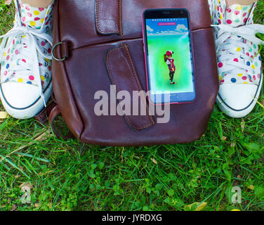 Dnipropetrowsk, Ukraine - Juli 23, 2016: Das Telefon mit Spiel Pokemon gehen im Park Stockfoto