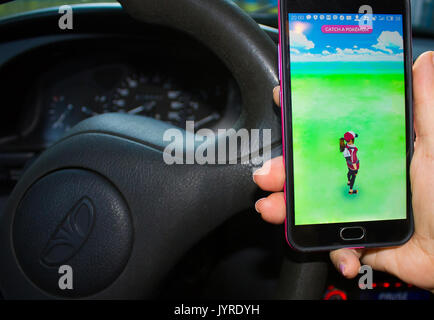 Dnipropetrowsk, Ukraine - 23. Juli 2016: Die weibliche Hand, die eine Telefon mit Spiel Pokemon gehen im Auto Stockfoto