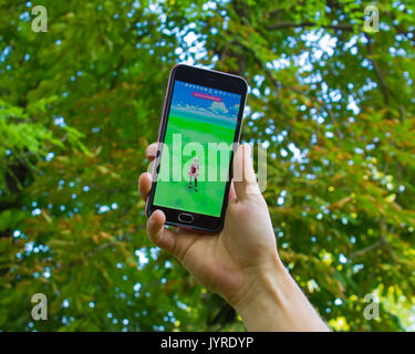 Dnipropetrowsk, Ukraine - 23. Juli 2016: Die männliche Hand Phone, die mit dem Game Pokemon gehen im Park Stockfoto