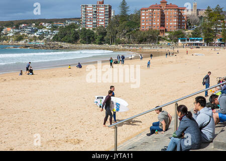 Junge Männer männliche Surfer mit Surfbrettern auf Manly Beach im Winter, Sydney, Australien Stockfoto