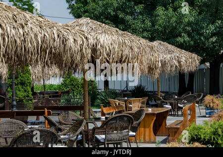 Blick auf die gemütliche Frühstücksecke für Sommer Erholung unter Palm Sonnenschirm mit Tisch, Stuhl und Bank aus Holz, park Borisova Gradina, Sofia, Bulgarien Stockfoto