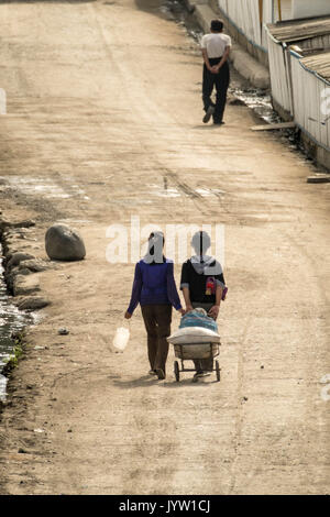 Hyesan, Ryanggang Provinz, Nordkorea - August 6, 2017: Menschen zu Fuß eine Straße auf einem frühen sonnigen Morgen. Stockfoto