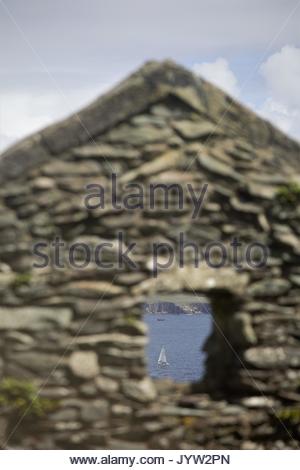 Ein Blick durch ein Fenster auf die Blasket Island vor der Westküste Irlands in einem Steinhaus, in dem einst Menschen lebten. Stockfoto